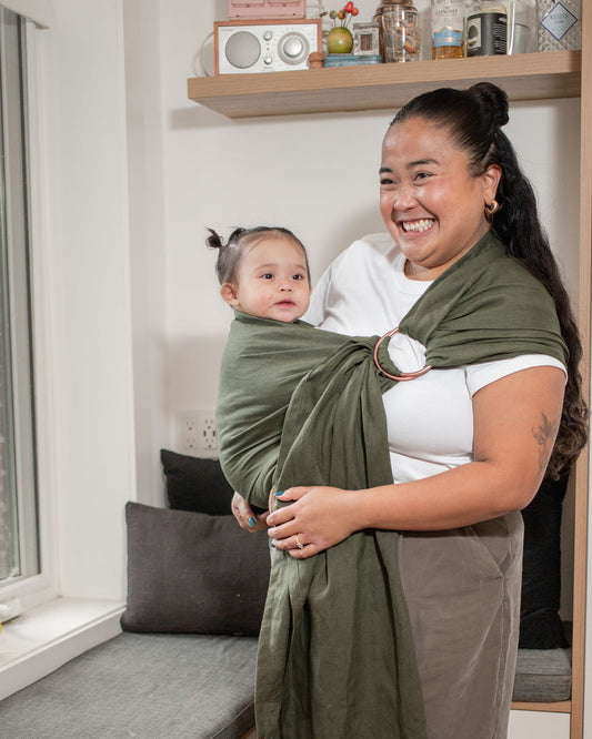 Woman babywearing baby in green linen ring sling