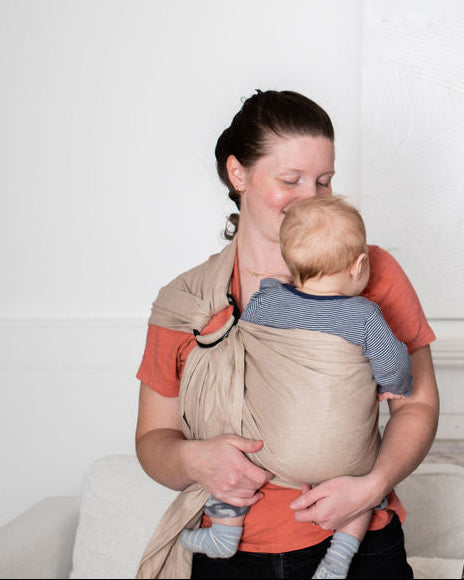 mom babywearing using a beige linen ring sling