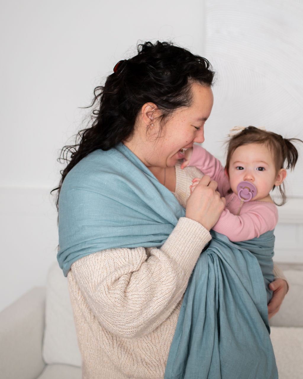 Woman with her baby  in a blue ring sling 