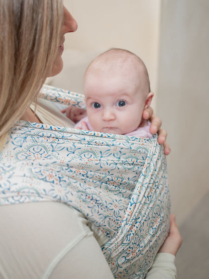 close up of mom wearing baby in stretchy Wrap Carrier Mediterranean Tile Inspired Print 