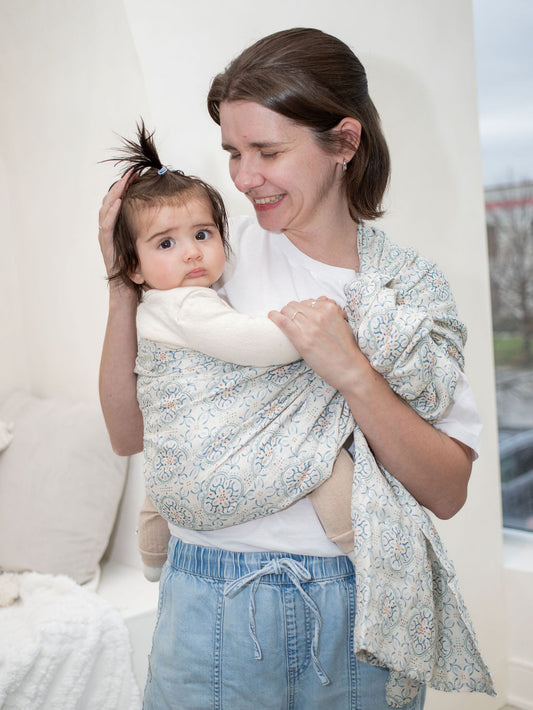 Mom wearing baby in double layer linen ring sling in Mediterranean inspired print