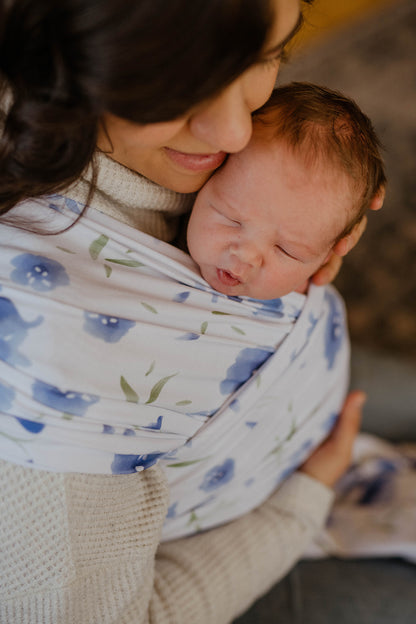 Mom snuggling newborn in wrap carrier